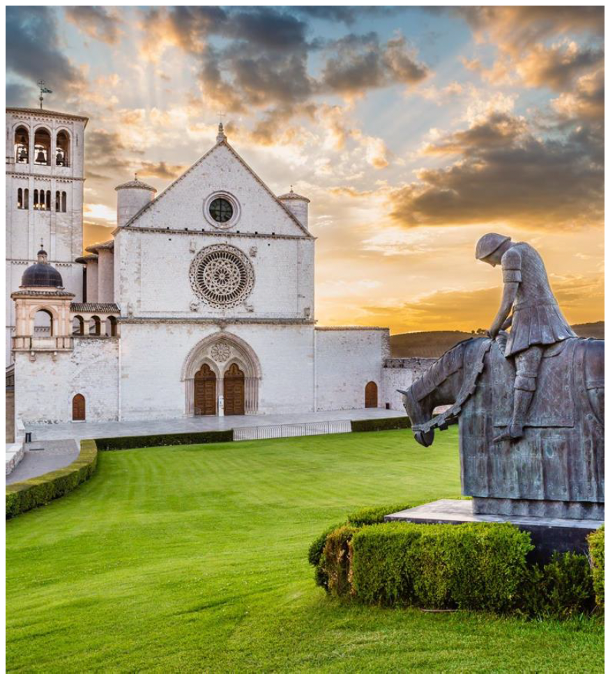Historic white church with a bell tower overlooking the sea at sunset.